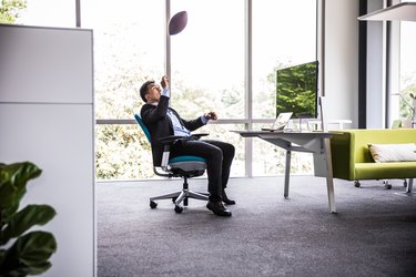 Man throwing football in modern business office