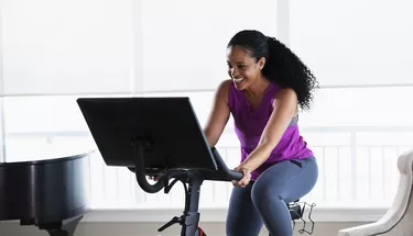 African-American woman on exercise bike at home