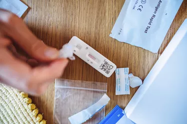 A woman using Covid-19 rapid self-test kit at home