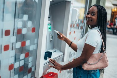 African american woman using credit card and withdrawing money from an ATM