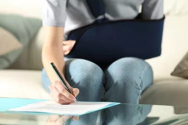 Handicapped woman with sling signing contract