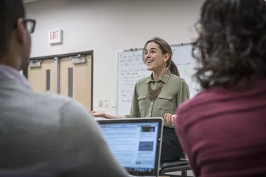 Professor talking to students in college classroom