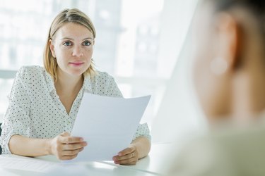 Woman reviewing resume report at conference table