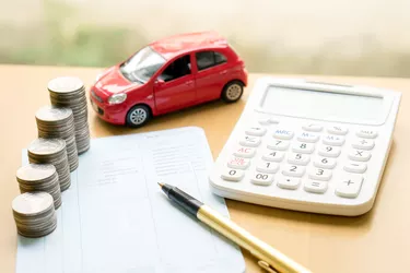 Coins stack in columns on saving book and car