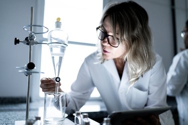 Woman working in a laboratory, using digital tablet