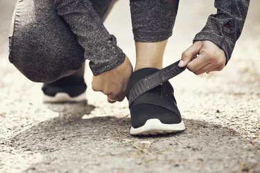 Female runner fastening velcro closure of shoe