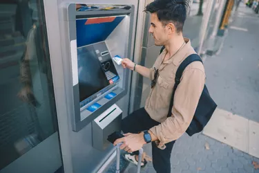 Tourist at the ATM withdrawing cash with credit card