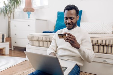 Happy African American enjoying spending money online