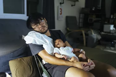 Asian father sleepy and holding daughter and daughter wake up in the night time