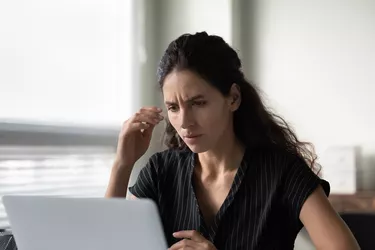 Close up frustrated woman reading bad news, using laptop