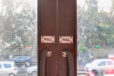 Pull engraved on plastic plate on wooden glass door of a metro station