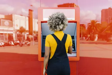 Woman with afro hairstyle using red ATM machine