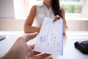 Businesswoman Giving Cheque To Colleague