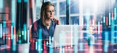 Businesswoman working at modern office.Technical price graph and indicator, red and green candlestick chart and stock trading computer screen background. Double exposure. Trader analyzing data