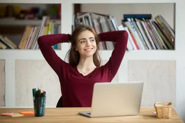 Satisfied female worker leaning in chair after finishing work