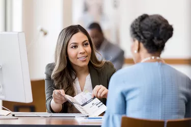 Bank employee explains bank services to new customer