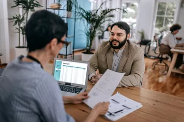 Confident businessman discussing with businesswoman at office