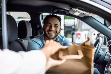Man smiles while picking up curbside order