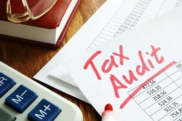 Tax audit handwriting on business accounting documents.