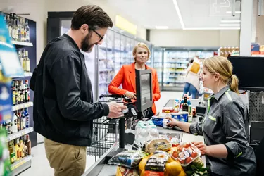 Mature Man Paying For Groceries At Checkout