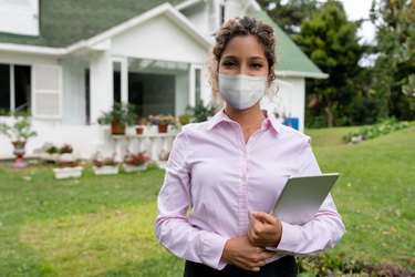 Real estate agent showing a suburb property wearing a facemask
