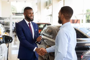 Smiling Car Seller Shaking Hands With Client After Successful Deal