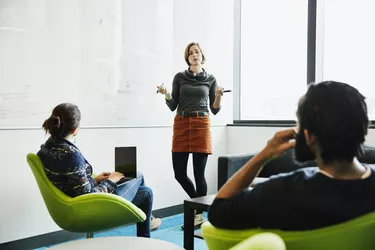 Female scientist leading project discussion with colleagues in research lab conference room