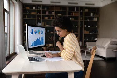 Concentrated young african american woman working with economic report.