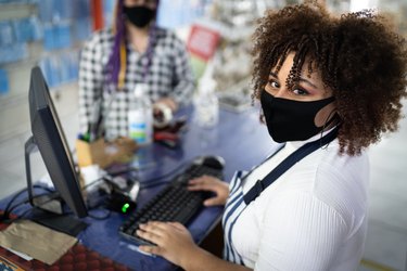 Portrait of cashier wearing face mask working in a store