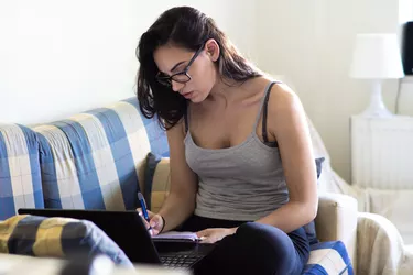 Girl looking at laptop computer screen while working from home