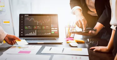 Stock exchange market concept, business teamwork brainstorming Meeting and looking on computer with graphs analysis candle line on table in night office, diagrams on screen.