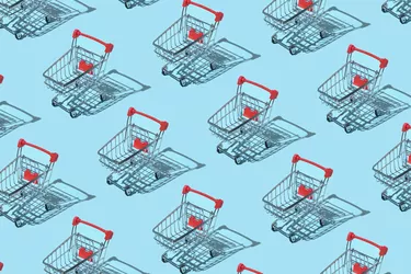 Pattern made of shopping trolley on blue background. Shopping and sale concept. Flat lay, top view