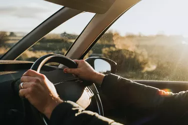 Hand holding steering wheel in a Car