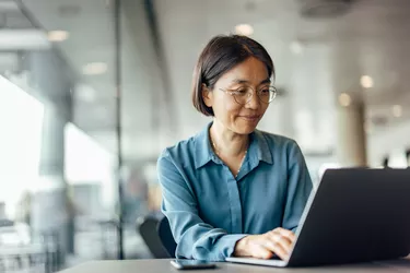 Confident Asian woman on laptop