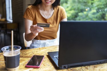 Woman in a cafe shopping online with credit card