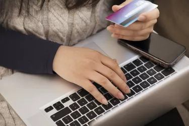 Close up of woman paying with credit card, ordering online.