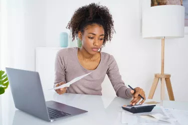 Black woman managing family budget at home table