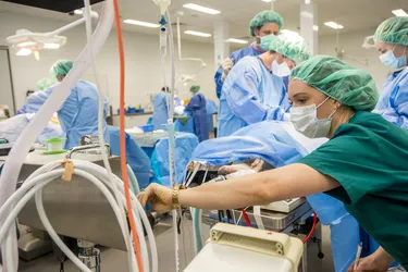 Anesthesiologist looking at monitor during surgery