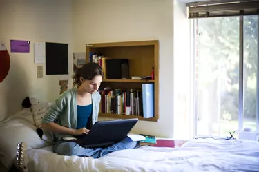 Young college student in her dorm room working on the computer