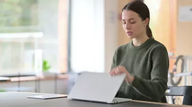 Young Woman Closing Laptop and Leaving