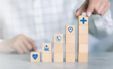 Hand arranging wood block with healthcare medical icon. Health insurance concept.