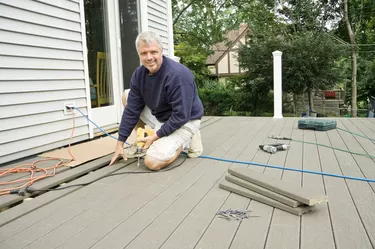 carpenter building a deck in the suburbs