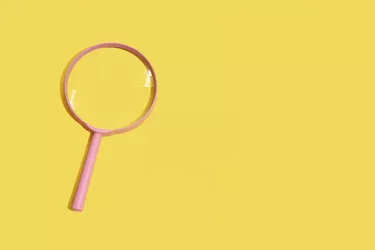 Pink Magnifying Glass On Yellow Background