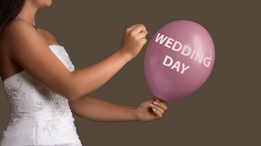 Bride lets a Balloon with Text burst with a needle
