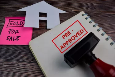 House For Sale write on a book and Red Handle Rubber Stamper Pre-Approved text isolated on the table.