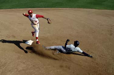 Infielder making double play, runner sliding into second base
