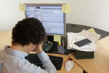 Anguished man doing taxes on his computer