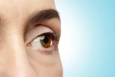 Close-up of female eye on blue background.