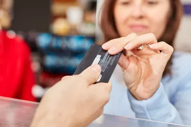 Cropped Hand Giving Credit Card To Cashier