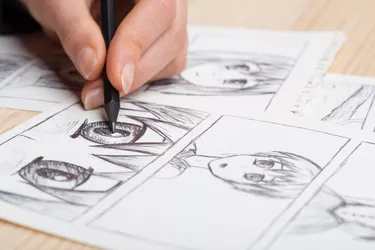 Artist drawing an anime comic book in a studio.